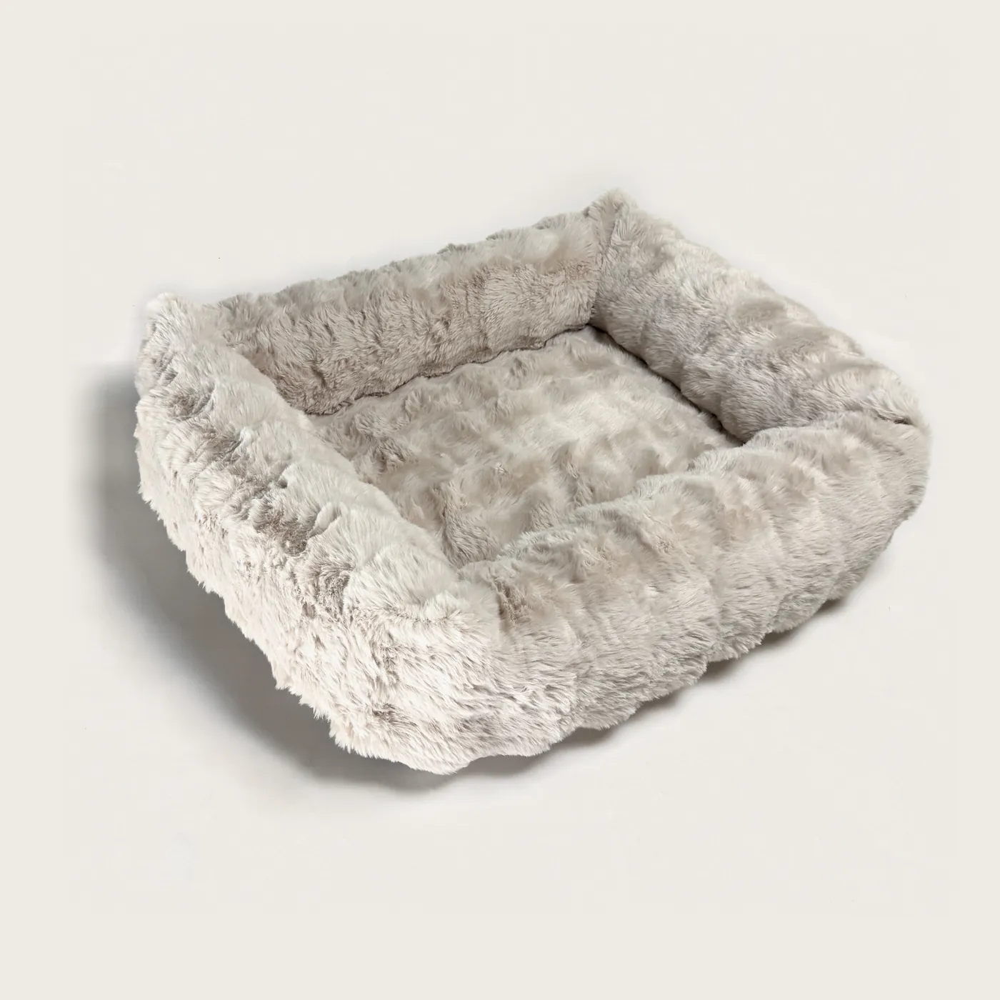 The Bliss Bed in Oat — an oatmeal-beige bolster bed in deep, plush faux fur.