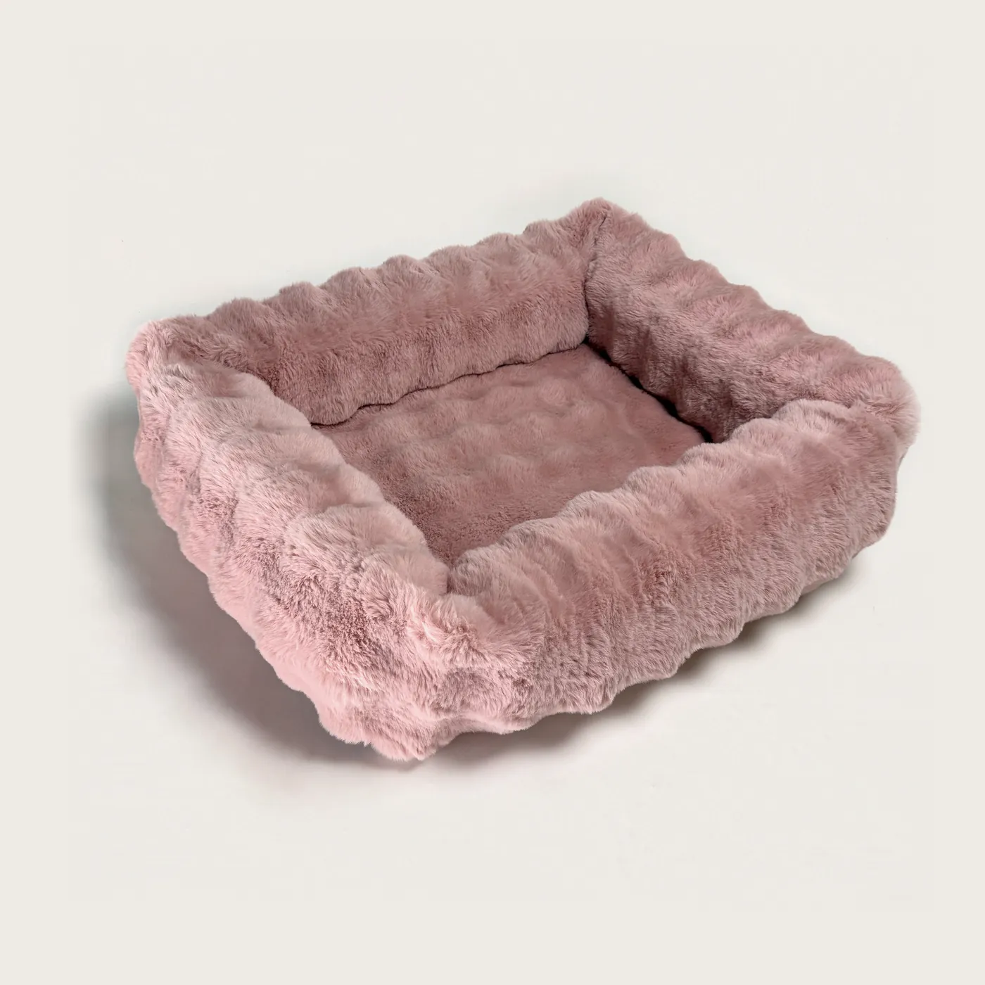 The Bliss Bed in Petal — a blush-pink bolster bed in deep, plush faux fur.