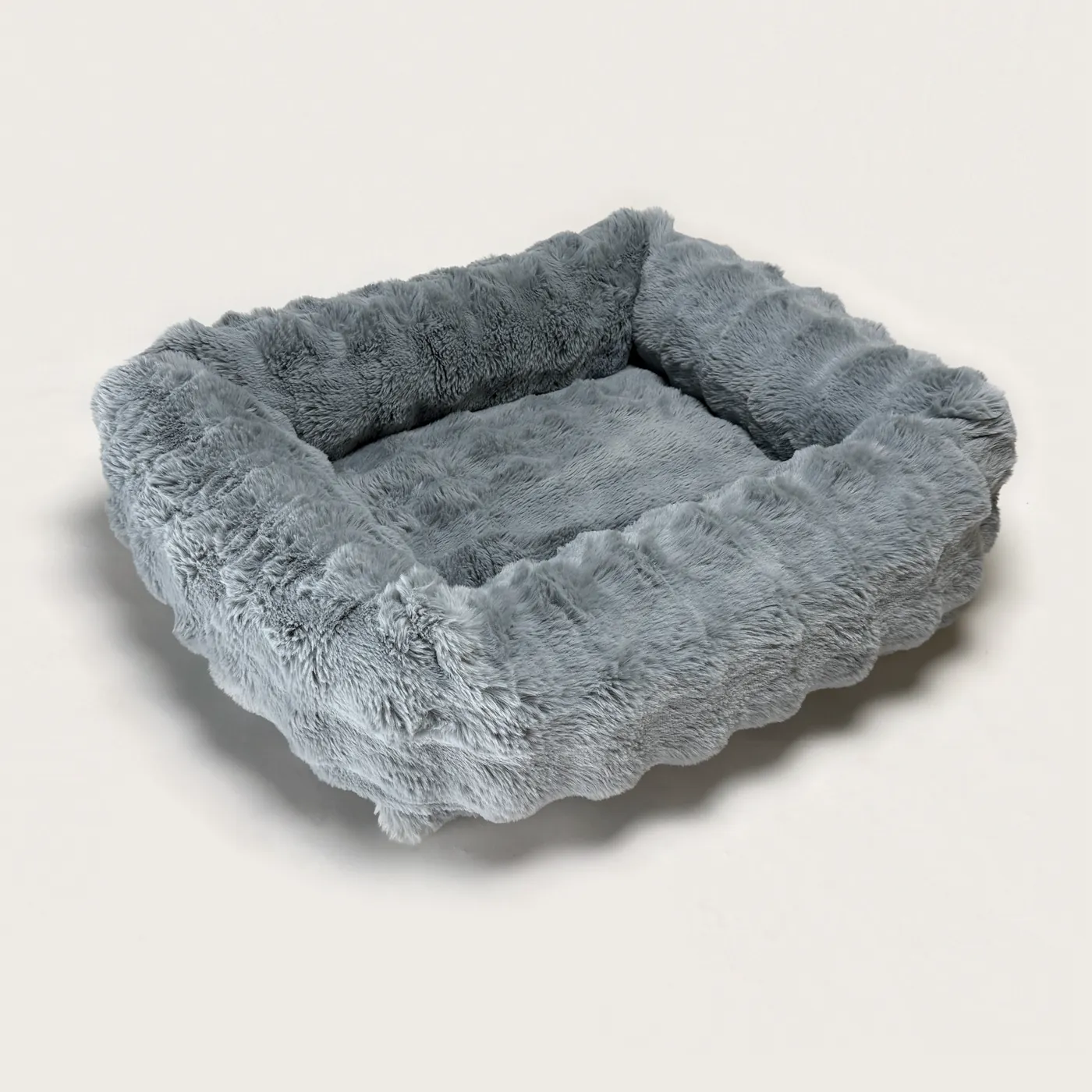 The Bliss Bed in Slate — a blue-grey bolster bed in deep, plush faux fur.