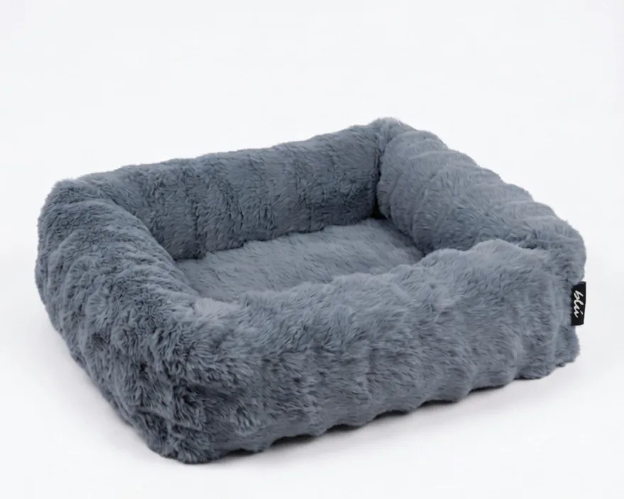 The Bliss Bed in Slate — a blue-grey bolster bed in deep, plush faux fur.